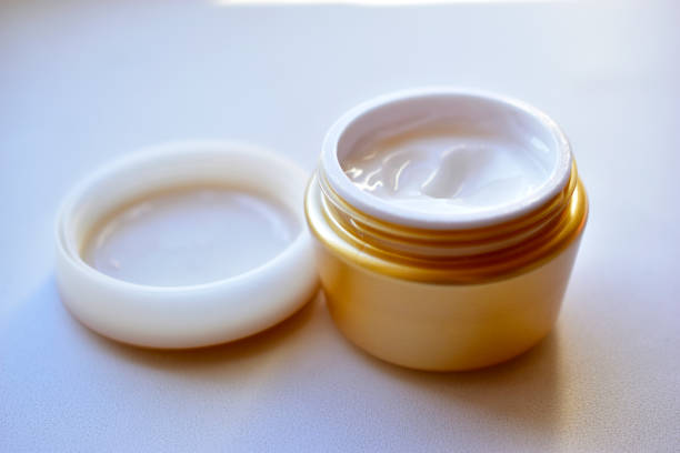 istock Yellow and white jar with white cosmetic cream 1279189377