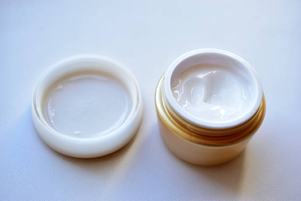 istock Yellow and white jar with white cosmetic cream 1279189390