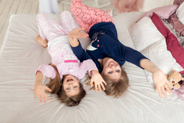 istock Little girl spends time playing with mom while lying in bed 1279193434