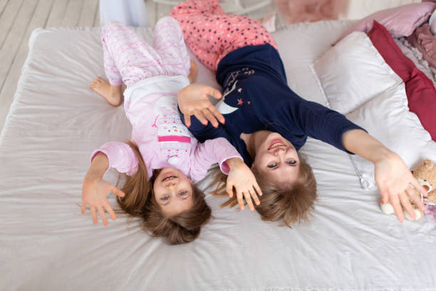 istock Little girl spends time playing with mom while lying in bed 1279193492
