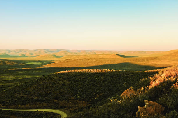 paysage spectaculaire dans la région aride de namaqualand en afrique du sud juste avant le coucher du soleil, avec des collines escarpées lointaines - sub saharan africa photos et images de collection