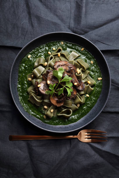 istock Spirulina pasta with mushrooms, spinach sauce and pine nuts 1279198745