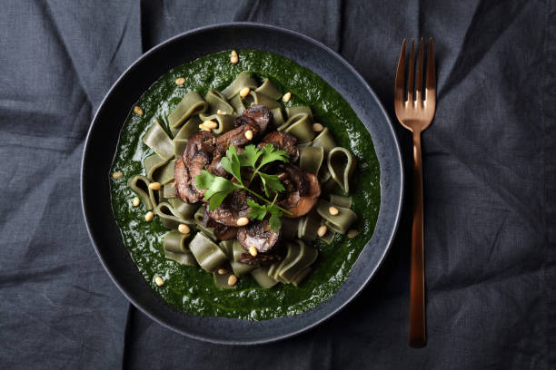 istock Spirulina pasta with mushrooms, spinach sauce and pine nuts 1279198756