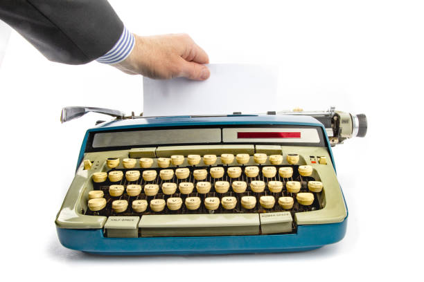 istock a business man hand pulling a sheet of paper from an old grungy manual portable typewriter with copy space 1279199425
