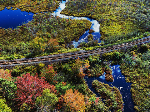 Aerial drone view of a rail line crossing a wetland area.