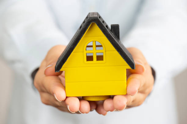 istock Woman Holding Model House 1279201312