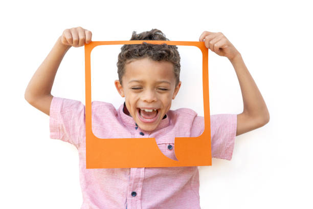 Happy Mixed Race Little Boy Showing Positive Feedback in Orange Speech Texting Bubble Happy Mixed Race Little Boy Showing Positive Feedback in Orange Speech Texting Bubble child laughing hysterically stock pictures, royalty-free photos & images