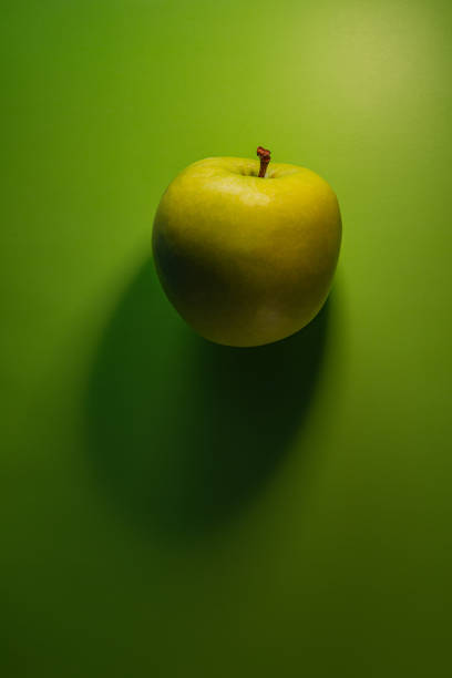 green apple  lies on a green background. Background for design.