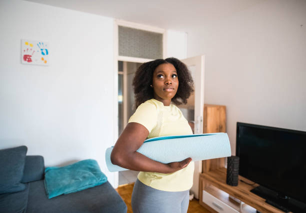 istock Black Young Woman Holding Exercise Mat And Looking Away 1279207907