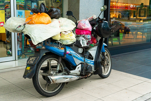 Bike loaded with things. Transport in Asia. Transportation of goods on a bike. Kuala Lumpur / Malaysia - 04.06.2020