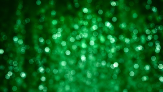 Green sparkle glitter tinsel with bokeh effect and selective focus. Festive background with bright raining lights. St Patricks, Christmas New Year's Eve concept. abstract looped 3D animation texture.