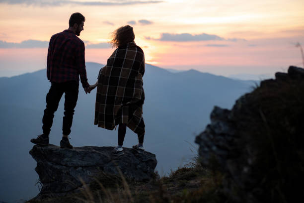 istock Lonely couple is standing at the cliff in the mountains 1279210940