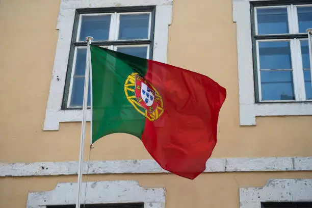 Photo of portuguese flag flying on building facade background