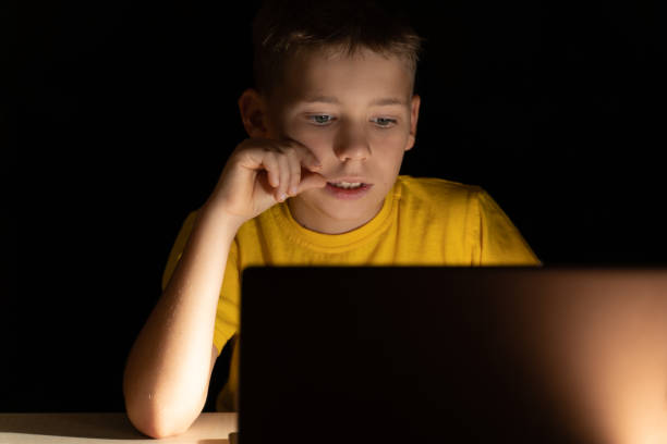 istock Portrait of a boy in front of a computer screen who communicates by video communication before bedtime 1279214435