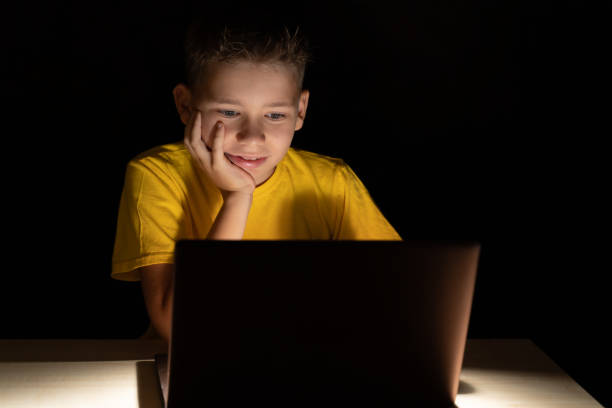 istock The boy communicates via video calling, through a laptop, sitting at a table in a dark room 1279214586