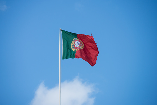 Closeup of portuguese flag floting on blue sky background
