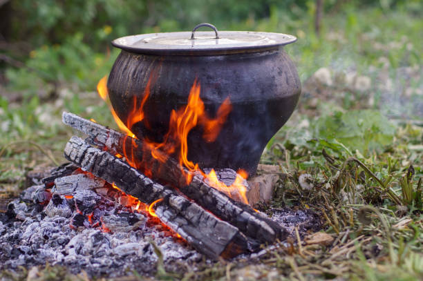 istock Cast iron on the fire, close-up. People resting in nature, lit a fire and cooked on it in fish soup. 1279216810