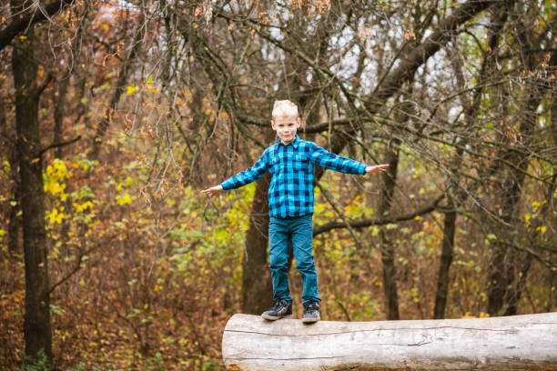 istock Preteen boy balance on fallen tree trunk 1279218924