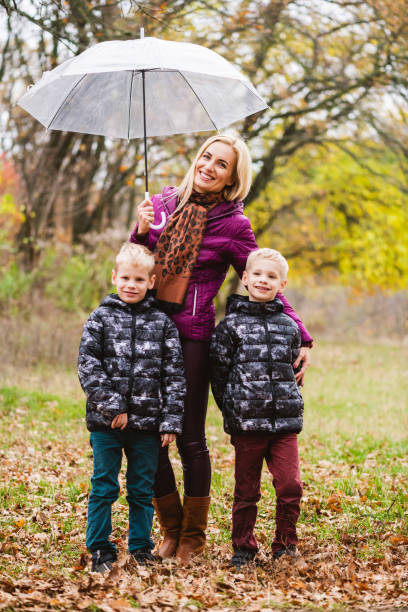istock Young mother and twin brothers under umbrella 1279218976