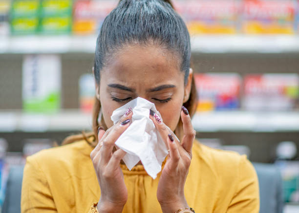 istock Sneezing into a tissue at a pharmacy 1279220094