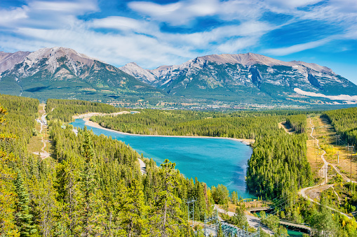 Landscape with the Rundle Forebay Reservoir and the city of Canmore Alberta Canada on a sunny day.