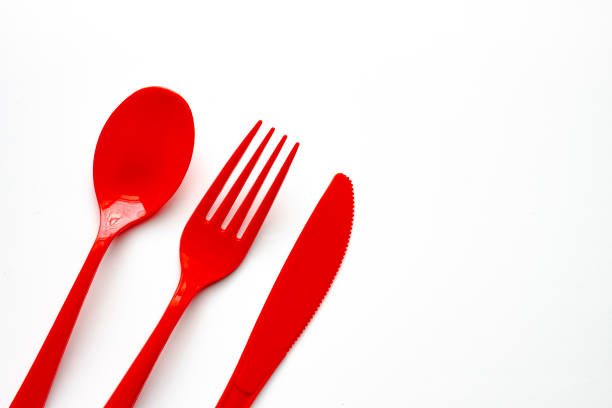 istock Close up to single use red plastic cutlery on a white background. Concept: Ban single use plastic 1279223843