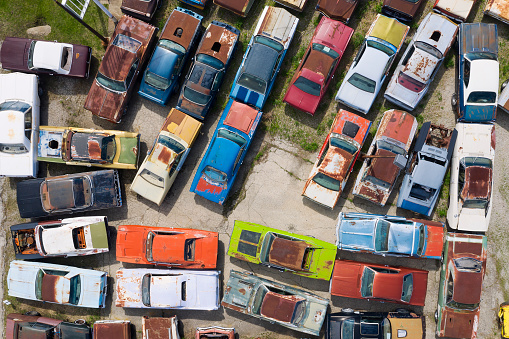 Junkyard full of classic American cars viewed from above.