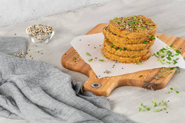 istock Raw veggie burger with lentils, vegetables and thyme leaves on kitchen countertop. 1279228512