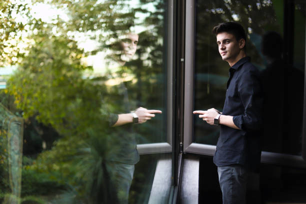 Photo of a mid adult man enjoying his coffee break outdoors, at the front porch of his home
