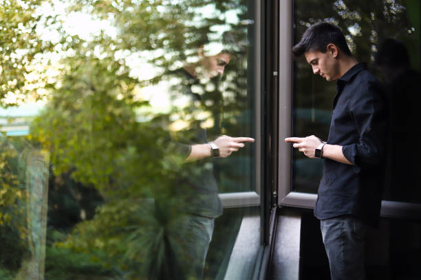 Happy Young Business Man Texting in Front Of The Window Reflection, Successful, Happy, Business Man Doing Business By Phone, Financial Success, Technology in Nature think green stock pictures, royalty-free photos & images