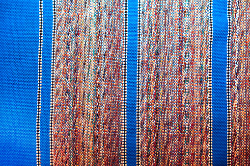 Woven carpet background made of blue and red threads