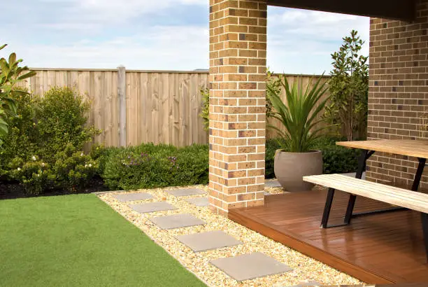 Combinations of artificial grass, paving tiles, decking, plants and pebble