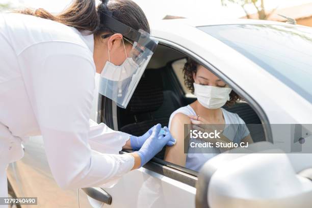 Nurse Performing Immunization In The Car Stock Photo - Download Image Now - Vaccination, COVID-19 Vaccine, Car
