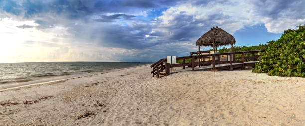 tiki hut boardwalk mène au sable blanc de barefoot beach - bonita springs photos et images de collection