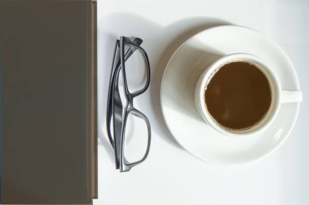 istock Top view, white coffee Cup, black men's glasses and brown diary, workplace 1279241540