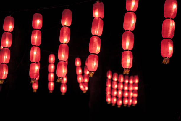 istock Red chinese paper lanterns lit in during a dark evening. Such lanterns are a tradition in China and Asia for the Chinese New Year. 1279241616