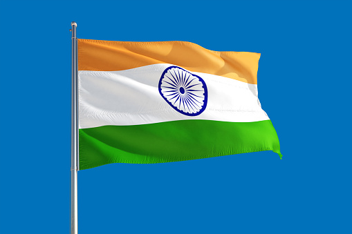 India national flag waving in the wind on a deep blue sky. High quality fabric. International relations concept.
