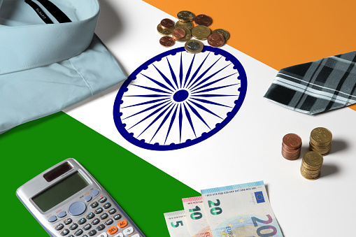 India flag on minimal money concept table. Coins and financial objects on flag surface. National economy theme.