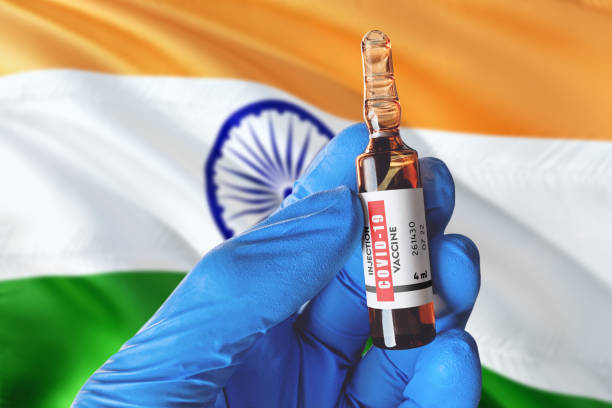 india flag with coronavirus covid-19 concept. doctor with blue protection medical gloves holds a vaccine bottle. coronavirus covid 19 vaccine research. - new delhi horizontal photography color image imagens e fotografias de stock