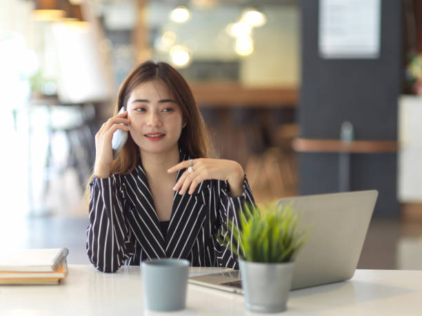 istock Female office worker talking on the phone while working with laptop 1279251449