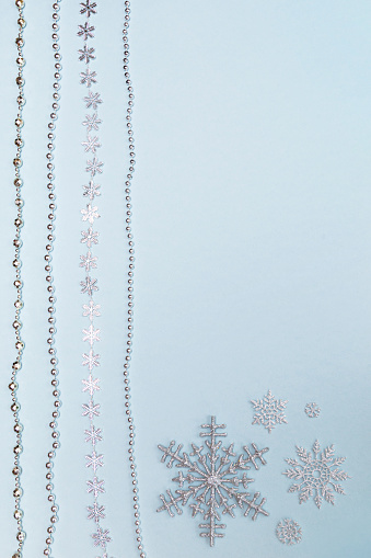 Christmas background image of silver snowflakes and beads on a blue background