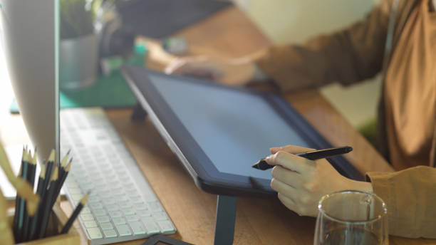 istock Female hands working with drawing tablet and computer on worktable in office room 1279255026