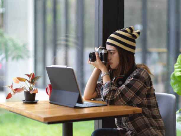 istock Female taking photo white digital camera while sitting at coffee table 1279255045
