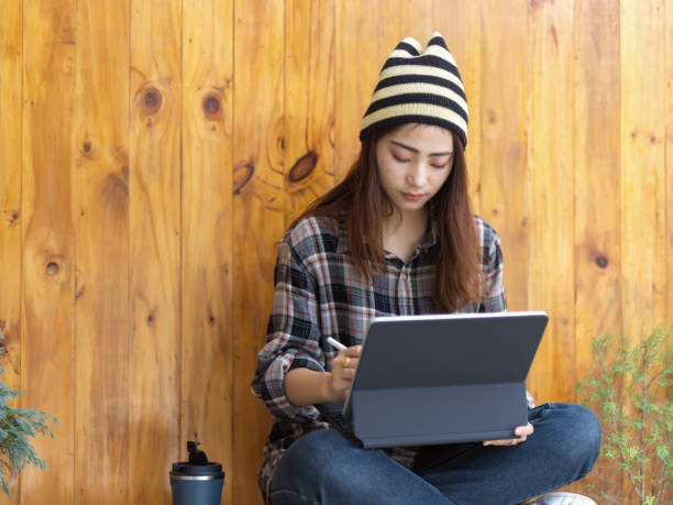 istock Female teenager using digital tablet while crossed legs sitting in cafe 1279255059