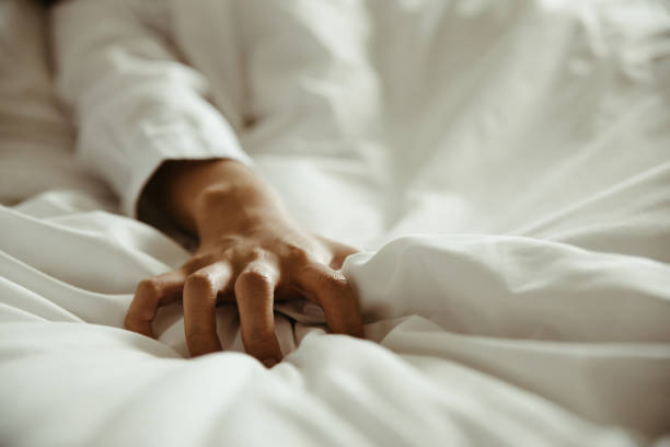 Close up hand of female pulling white sheets in ecstasy , feeling and emotion concept Close up hand of female pulling white sheets in ecstasy , feeling and emotion concept human sexual behavior stock pictures, royalty-free photos & images