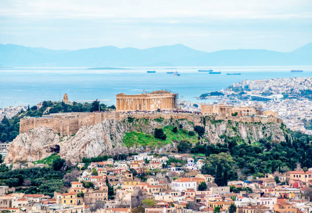 The Acropolis of Athens with Filopappos or Philopappou Hill and the Saronic Gulf. View of the Acropolis of Athens, Greece, with Filopappos Hill, the Saronic Gulf and the port of Piraeus in the background. Picture taken from Mount Lycabettus. piraeus photos stock pictures, royalty-free photos & images