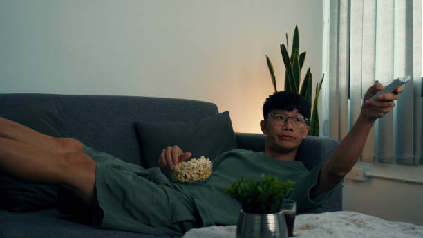 istock Asian guy is relaxing for the weekend by watching series his home at night. 1279268330