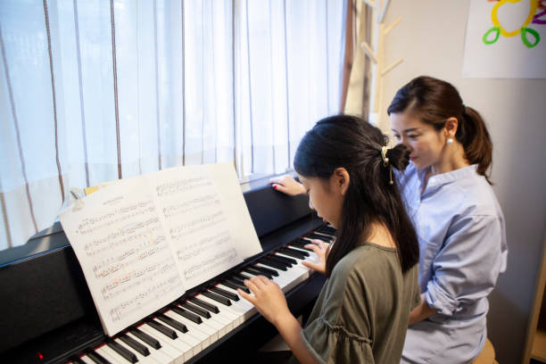 istock Daughter taking piano lessons with her mother 1279271707
