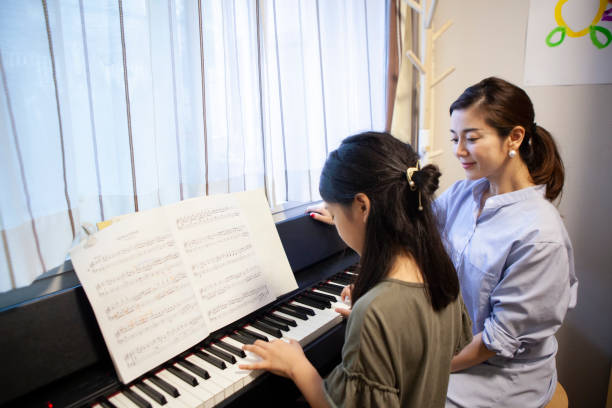 istock Daughter taking piano lessons with her mother 1279271730