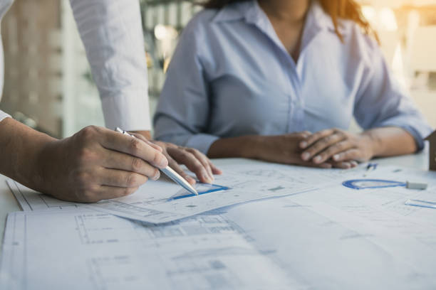 istock Architects engineer working with blueprints on table and discussing project together at the meeting in the office. 1279273479